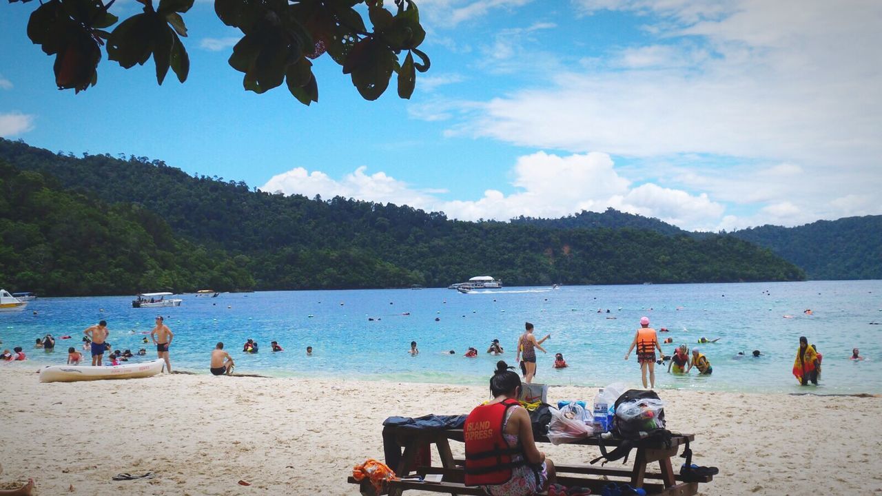 TOURISTS SITTING ON BEACH