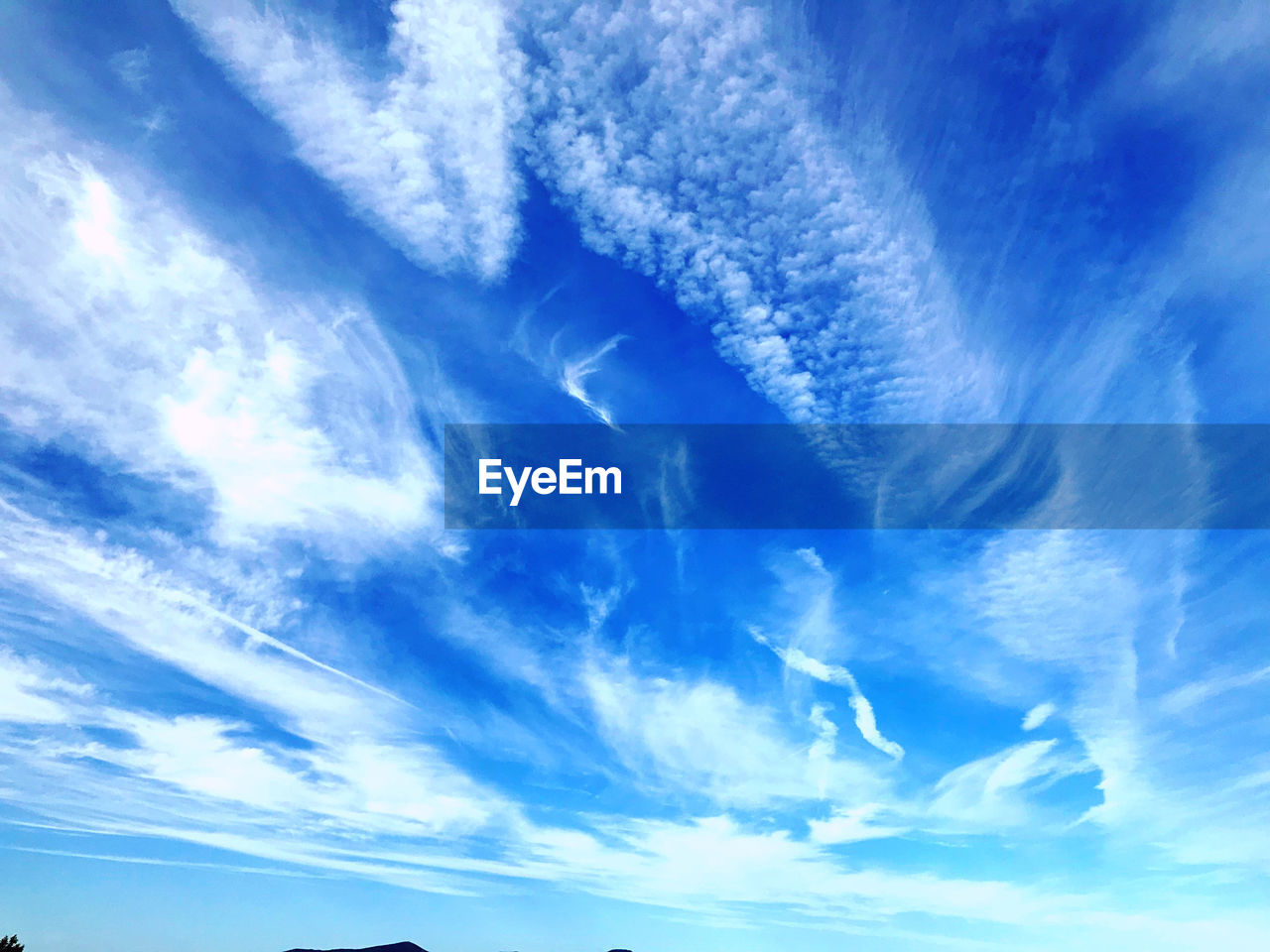 LOW ANGLE VIEW OF VAPOR TRAIL IN BLUE SKY