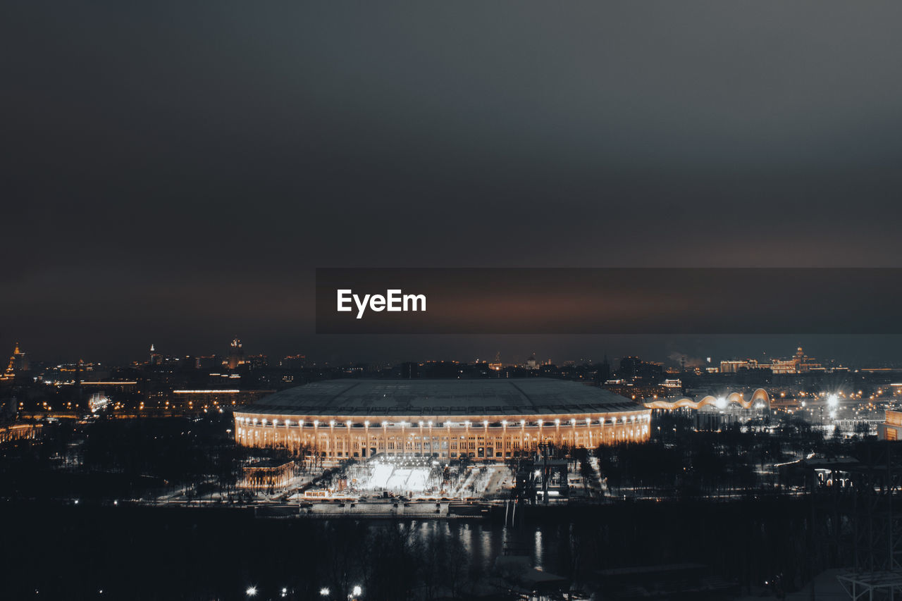 Illuminated luzhniki stadium against sky at night