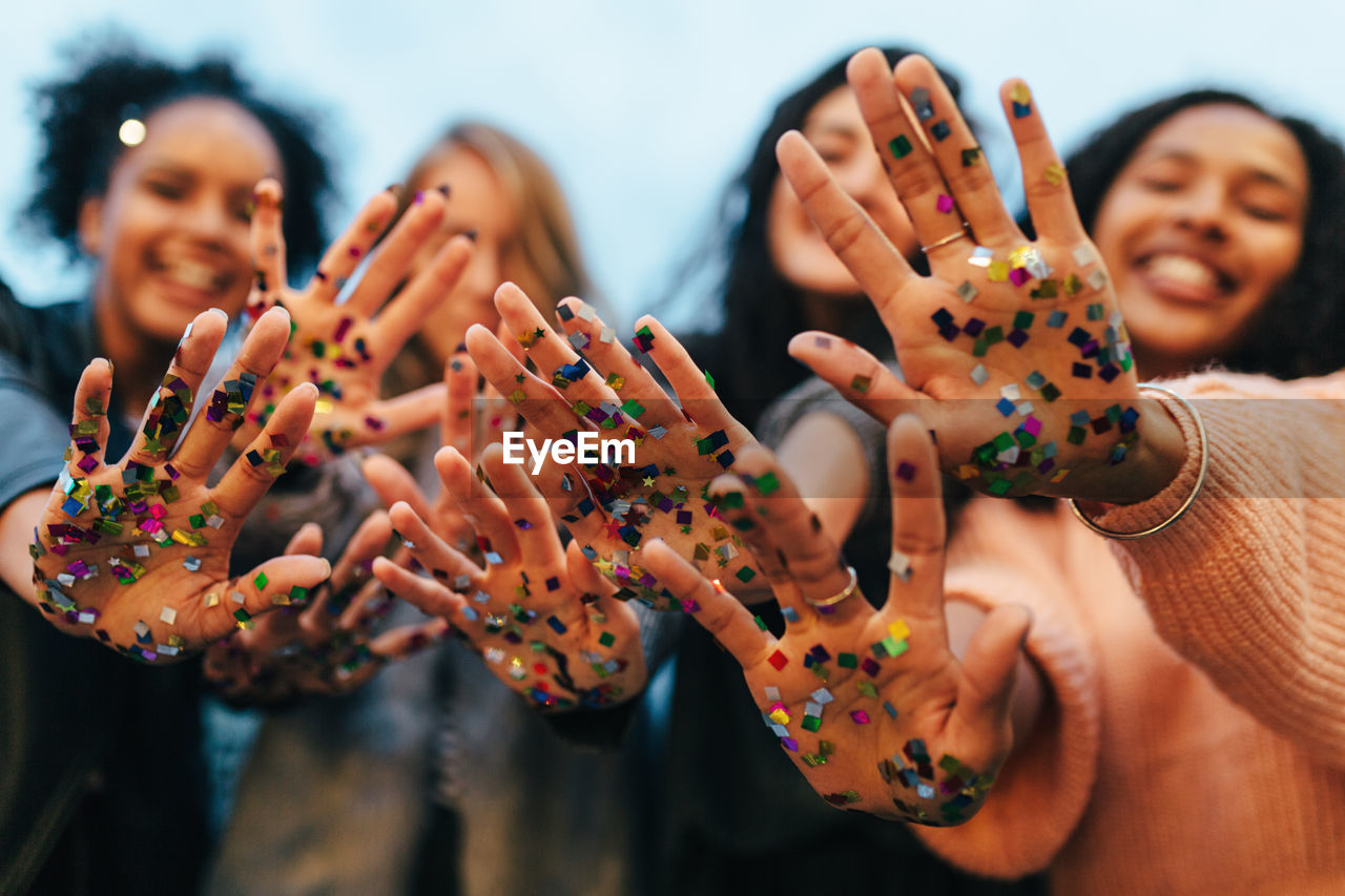 Female friends showing confetti on hands