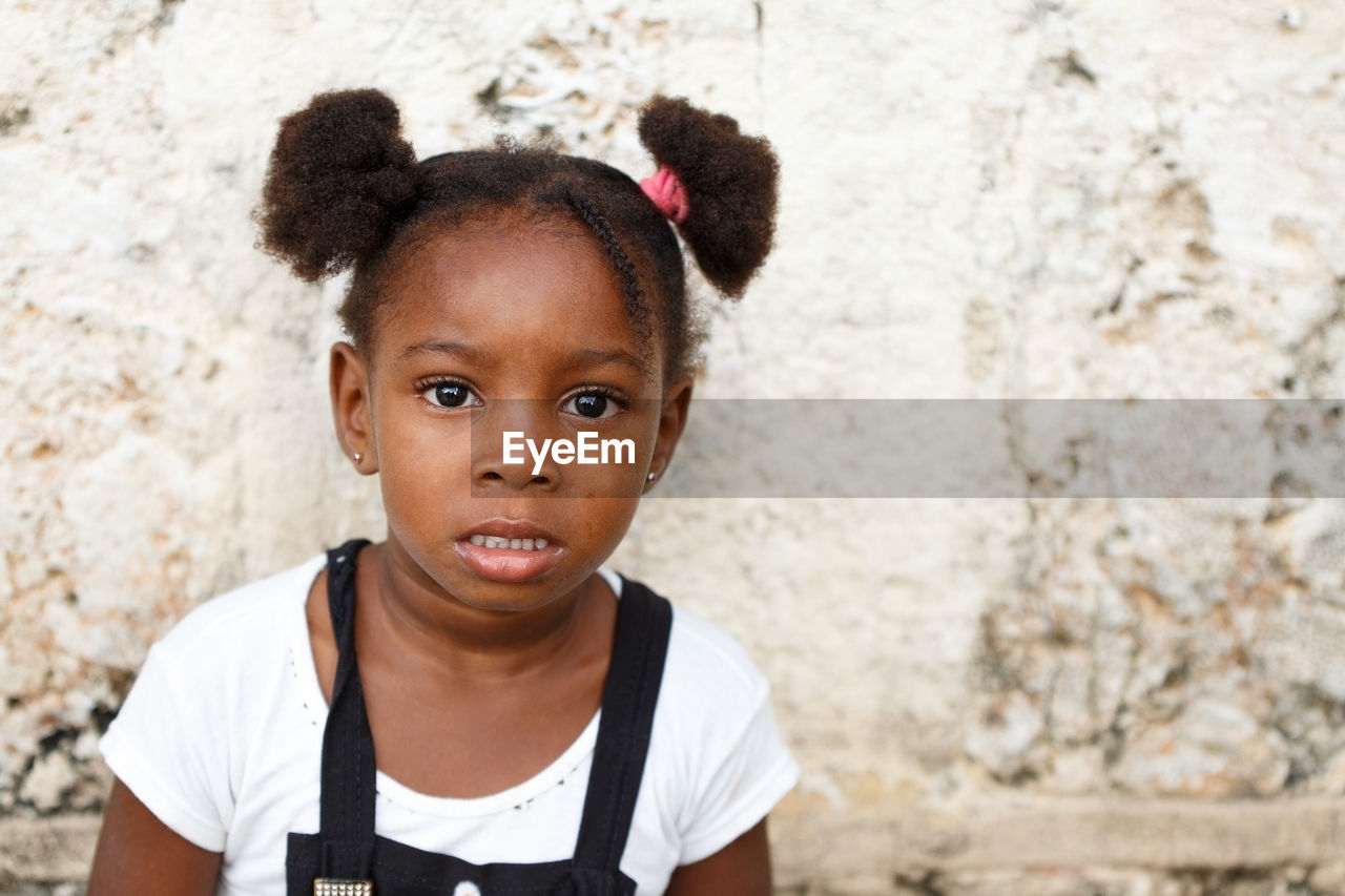 Portrait of girl against wall