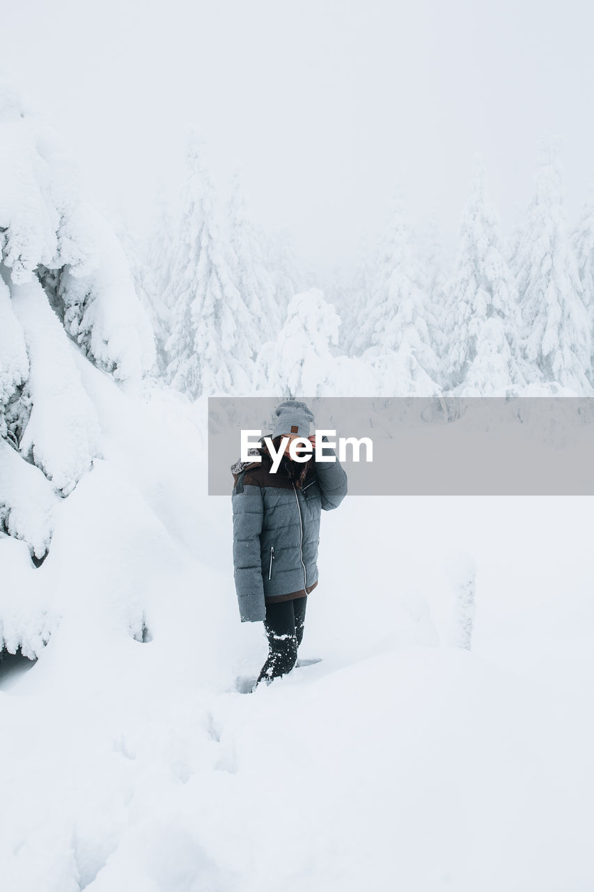 Side view of person standing on snow covered field