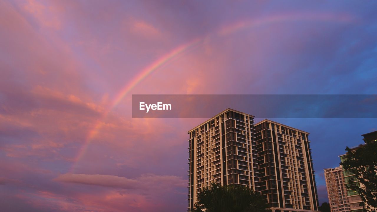 Low angle view of skyscraper against sky during sunset