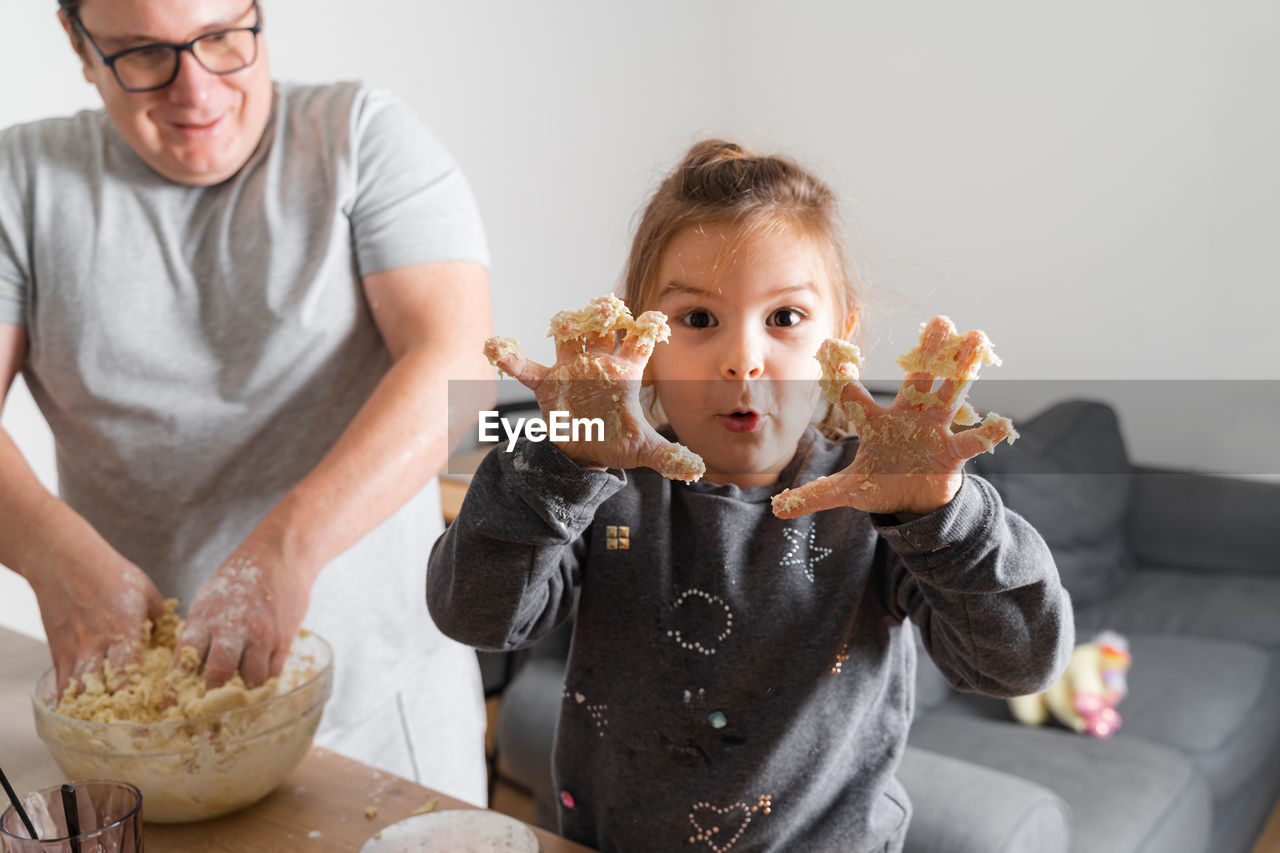 Portrait of smiling senior man holding food at home