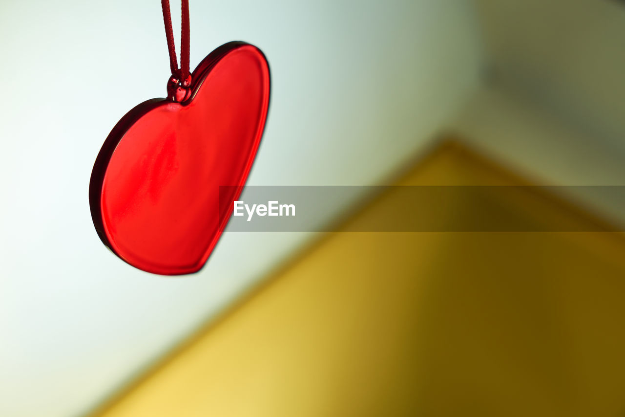 LOW ANGLE VIEW OF RED HANGING ON WALL