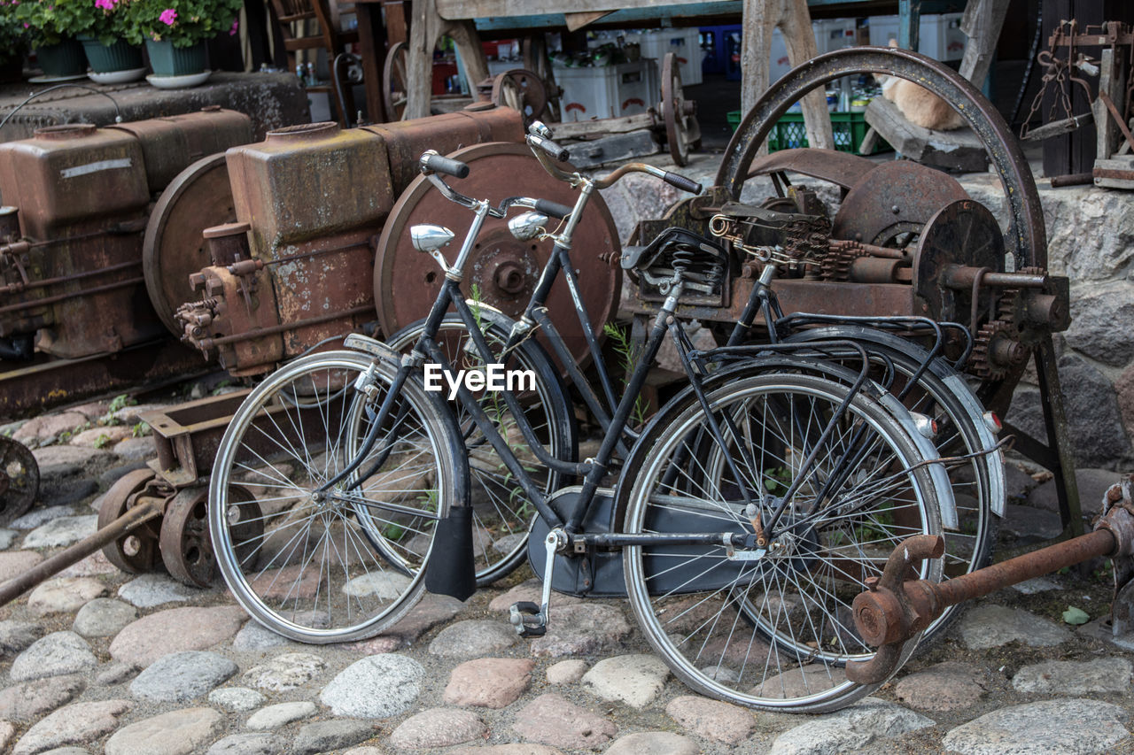 transportation, mode of transportation, no people, wheel, land vehicle, day, bicycle, abandoned, stationary, old, obsolete, damaged, outdoors, rusty, metal, architecture, in a row, deterioration, run-down, ruined, spoke