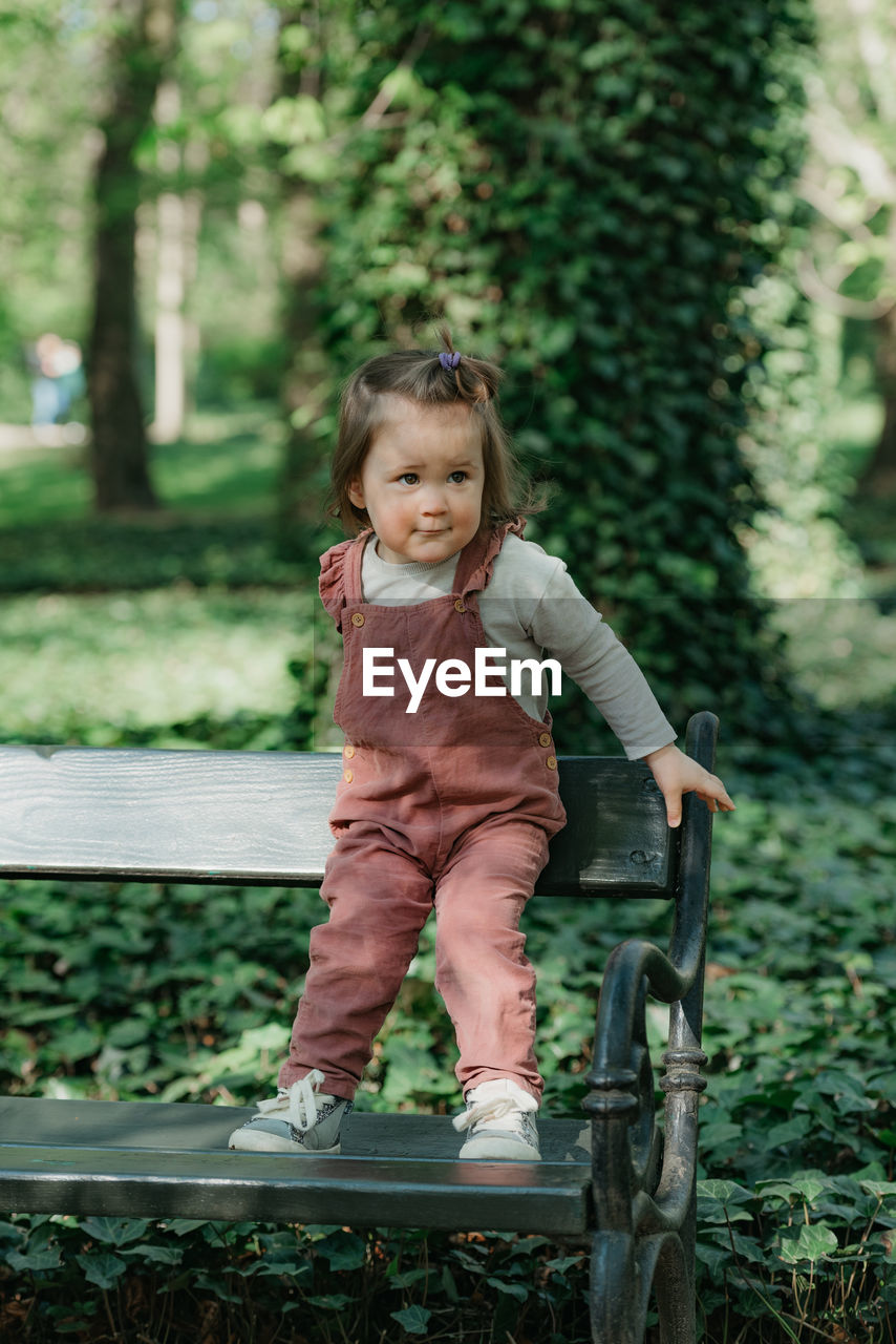 portrait of cute girl sitting on bench