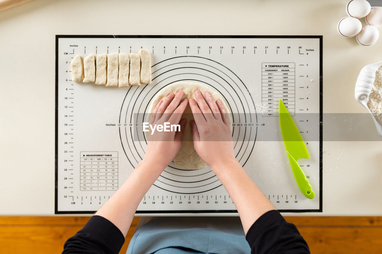 Cropped hand of woman making dough