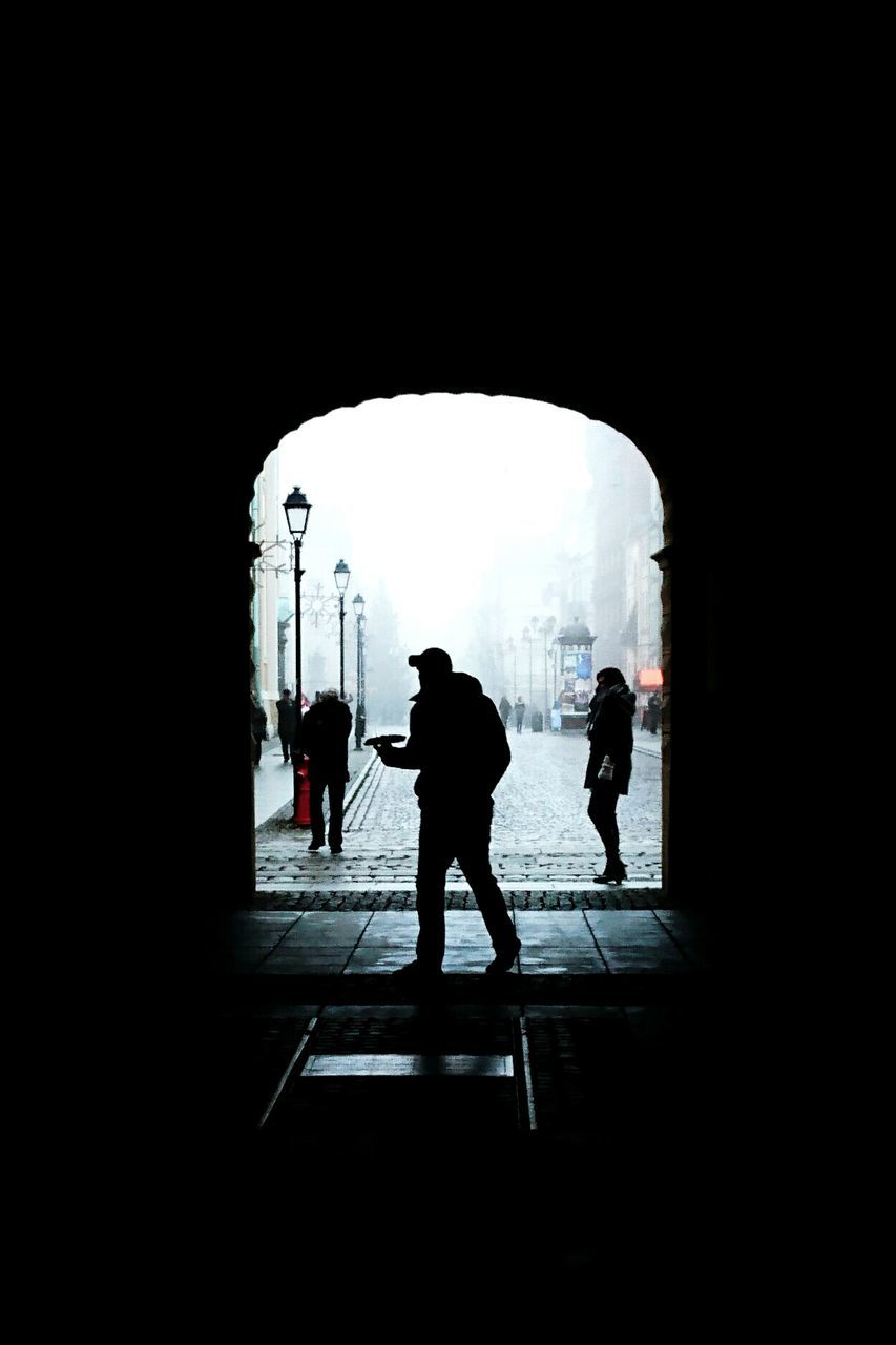 Silhouette man walking by entrance