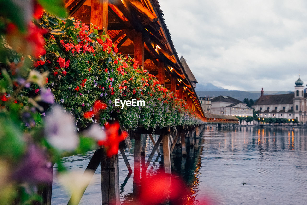 Scenic view of river by buildings against sky