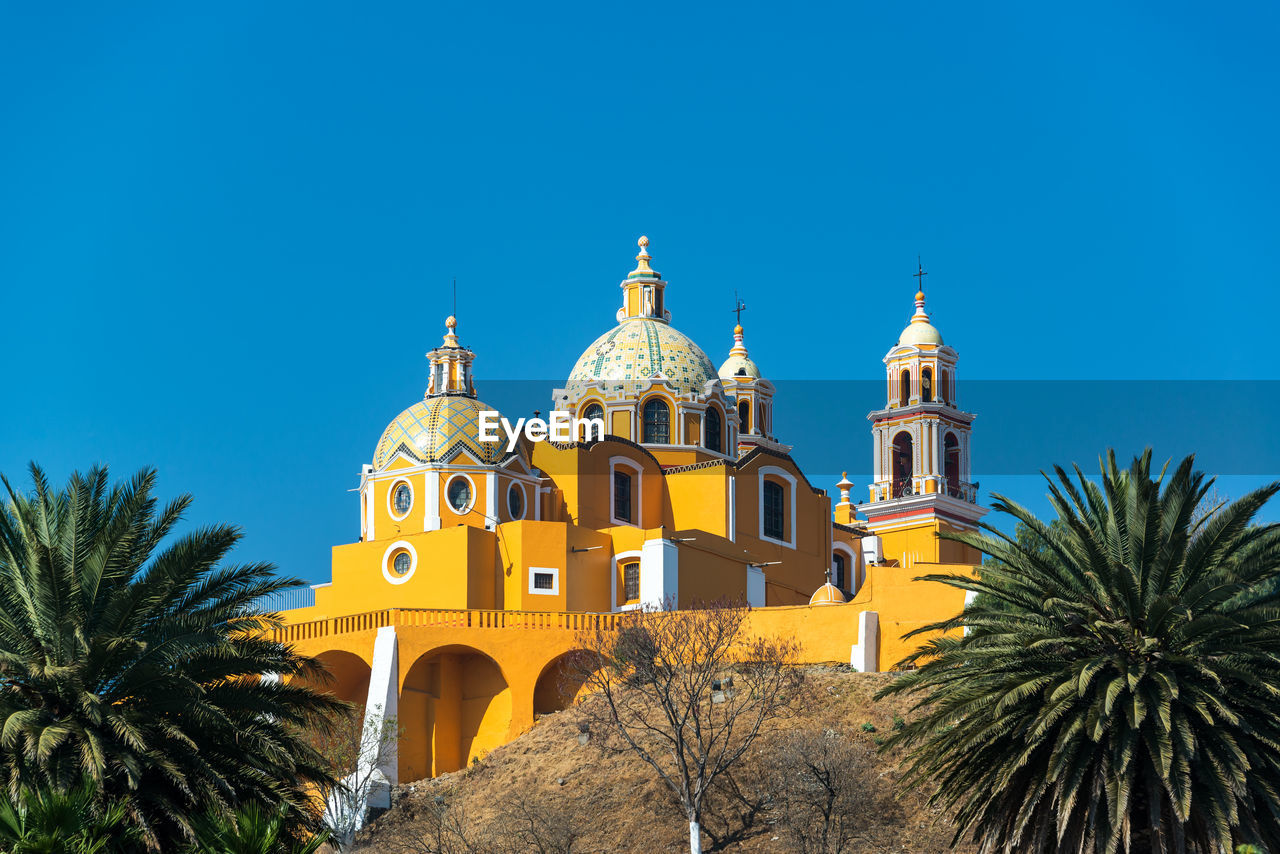 Our lady of remedies church against clear blue sky with palm trees in backgrounds