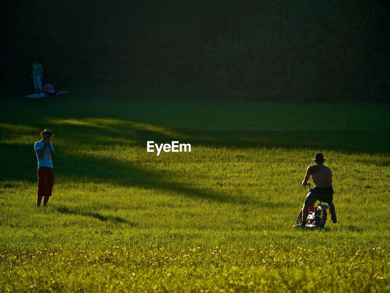 REAR VIEW OF MAN AND WOMAN ON FIELD DURING RAINY DAY