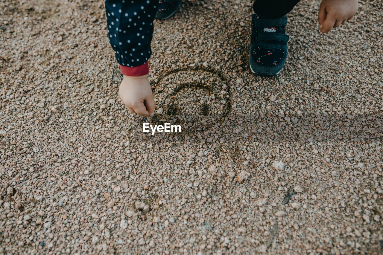 Low section of child standing on sand