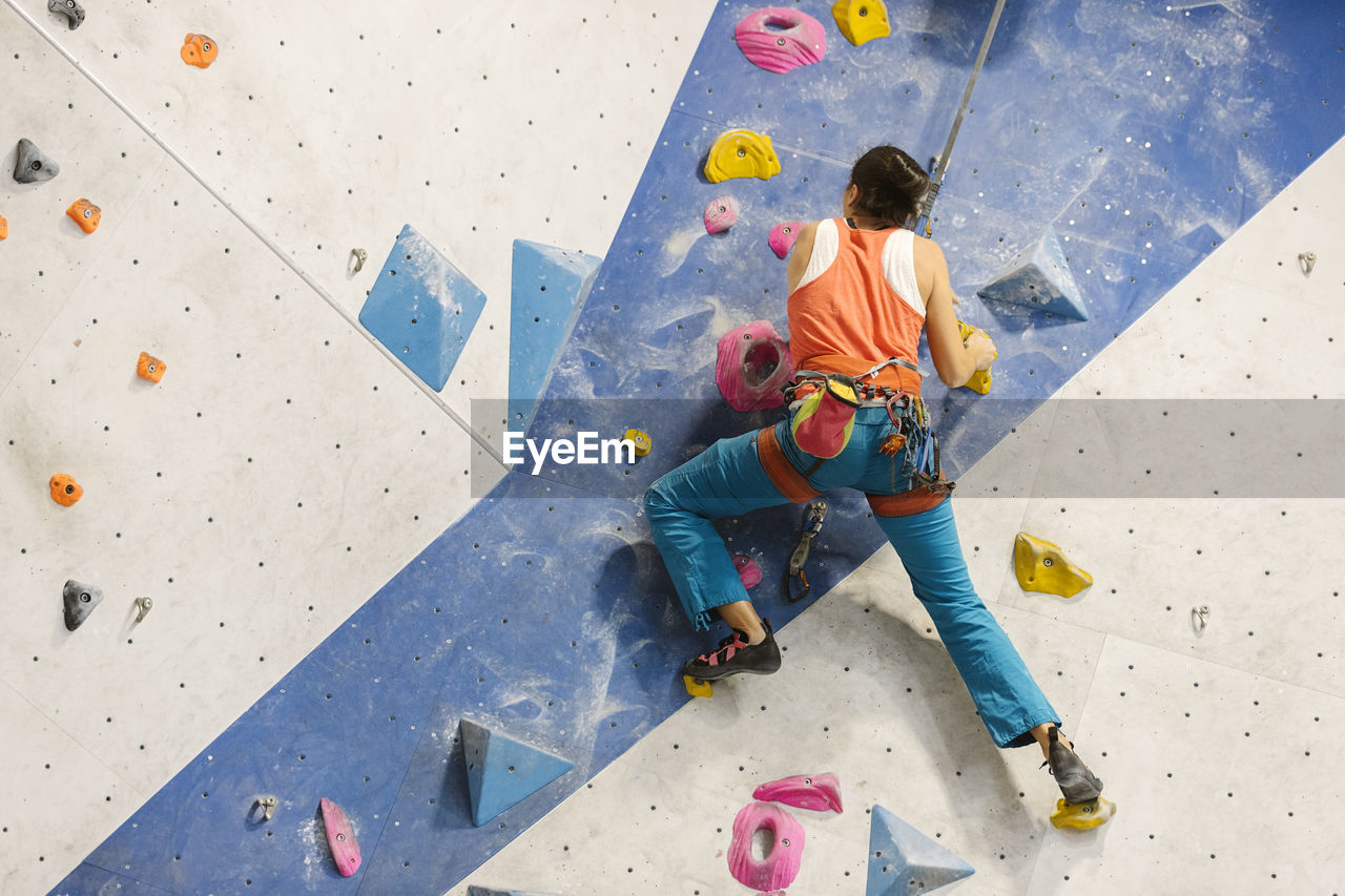 Low angle view of woman climbing on wall