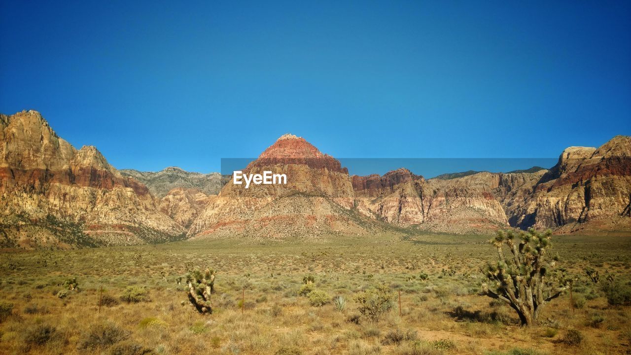 Scenic view of mountain against blue sky