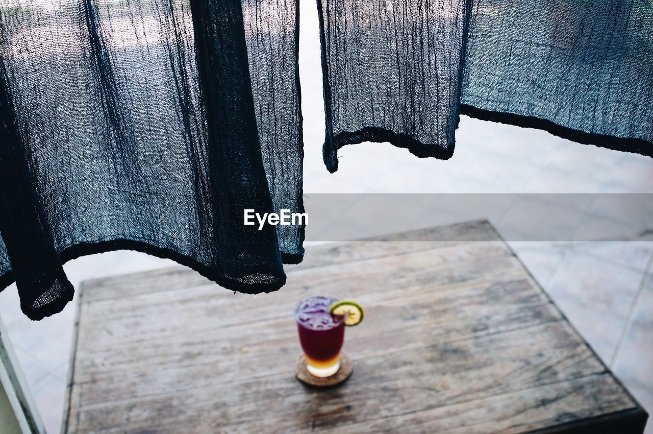 Close-up of black curtain over drink on table