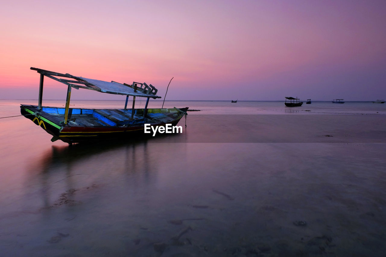 FISHING BOAT MOORED ON SEA AGAINST SKY