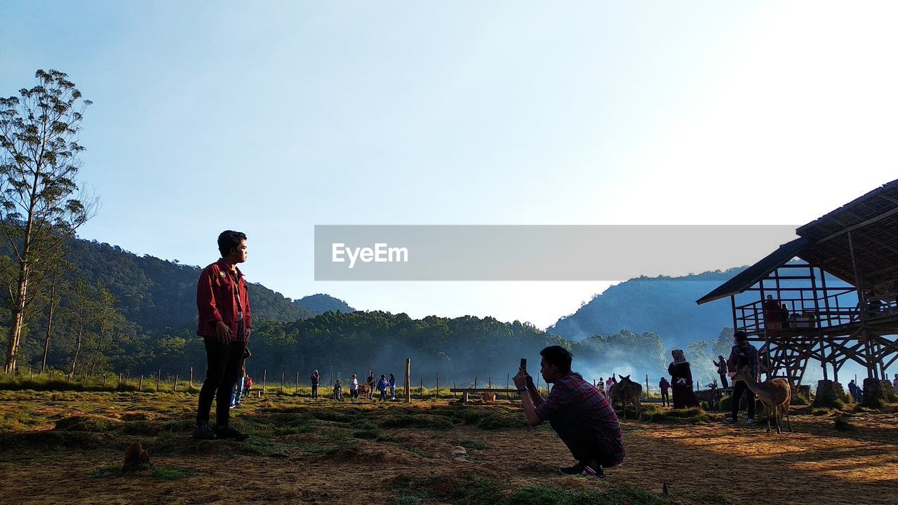 Man photographing friend standing on land