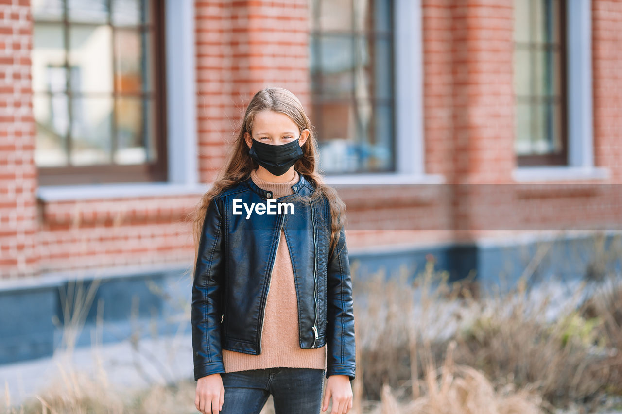 Girl wearing mask while standing outdoors