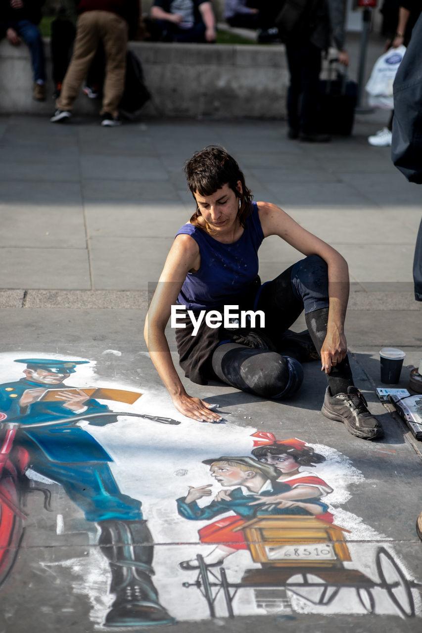 MAN AND WOMAN SITTING IN STREET