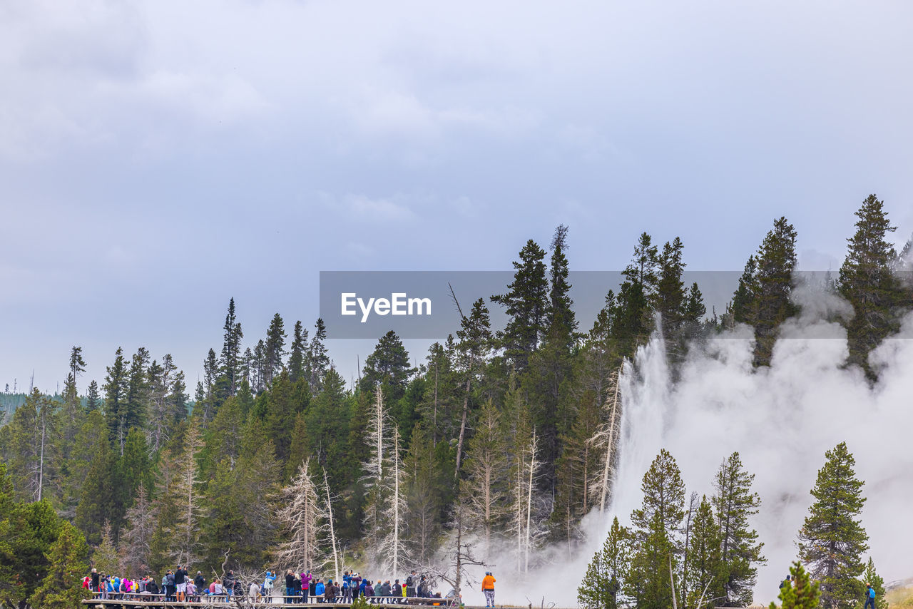 GROUP OF PEOPLE ON MOUNTAIN AGAINST SKY