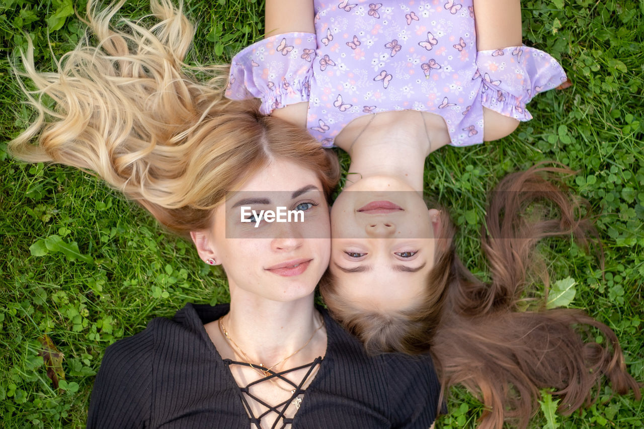 high angle view of young woman sitting on grassy field