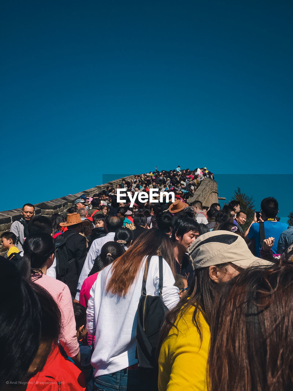 Group of people standing against clear blue sky