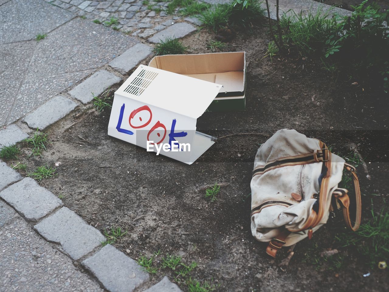 Look written on cardboard paper by abandoned bag