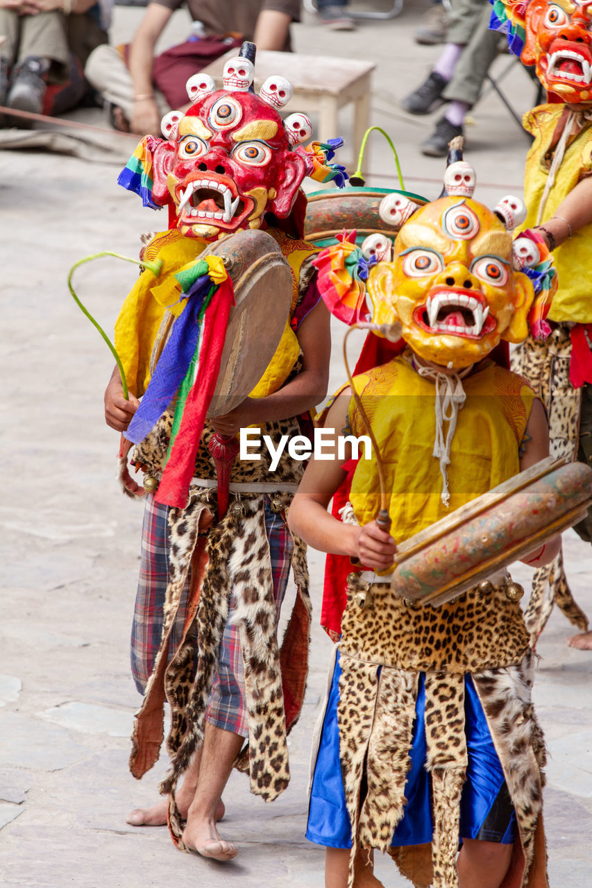 FULL LENGTH OF PEOPLE DANCING ON STREET DURING TRADITIONAL FESTIVAL