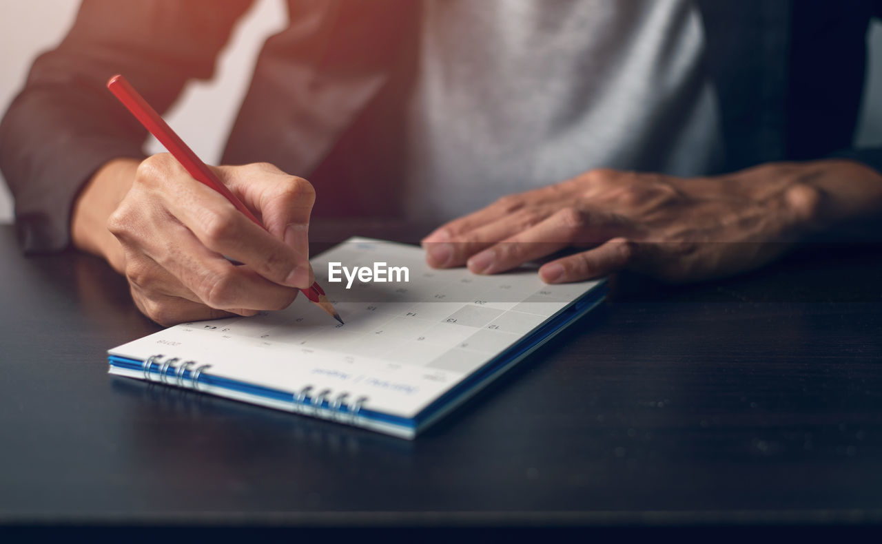 Man hand is write a memo on a calendar