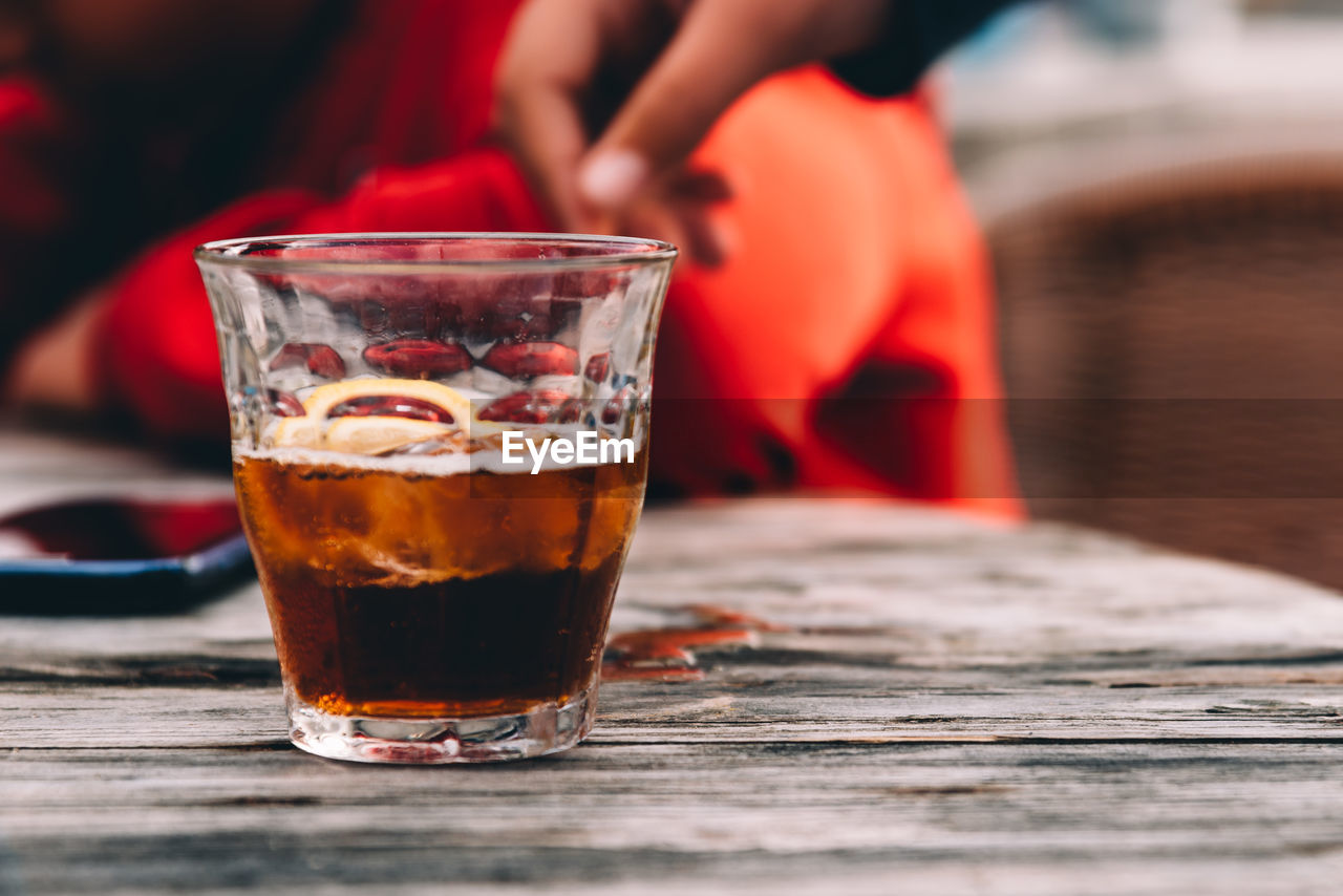 Glass of cola on wooden table at bar