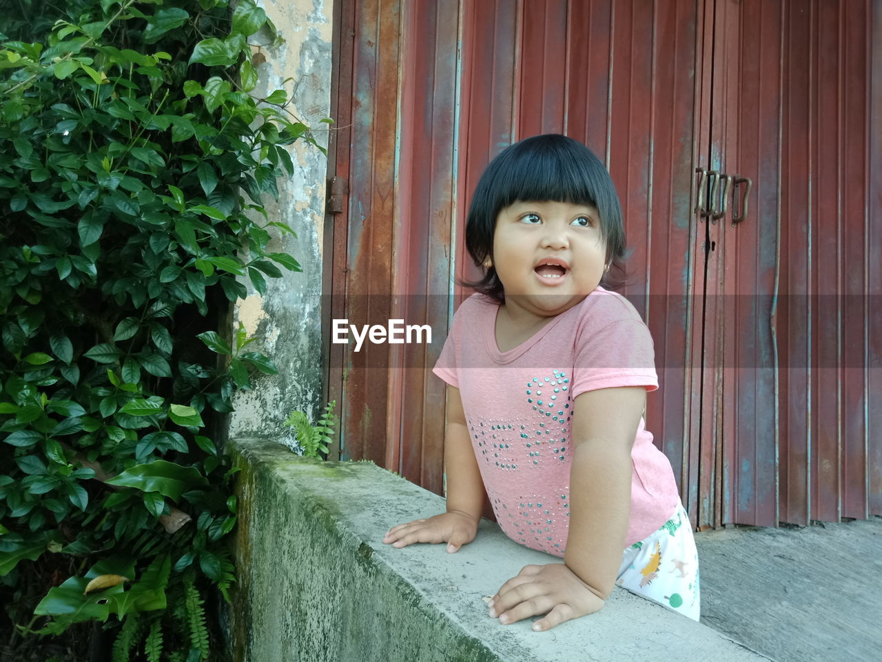 PORTRAIT OF A GIRL LOOKING AWAY AT ENTRANCE OF BUILDING