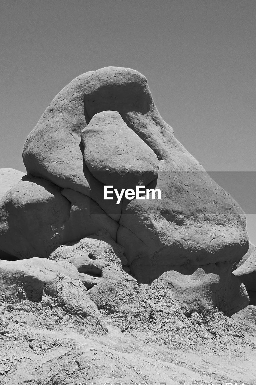 Low angle view of rocks against clear sky