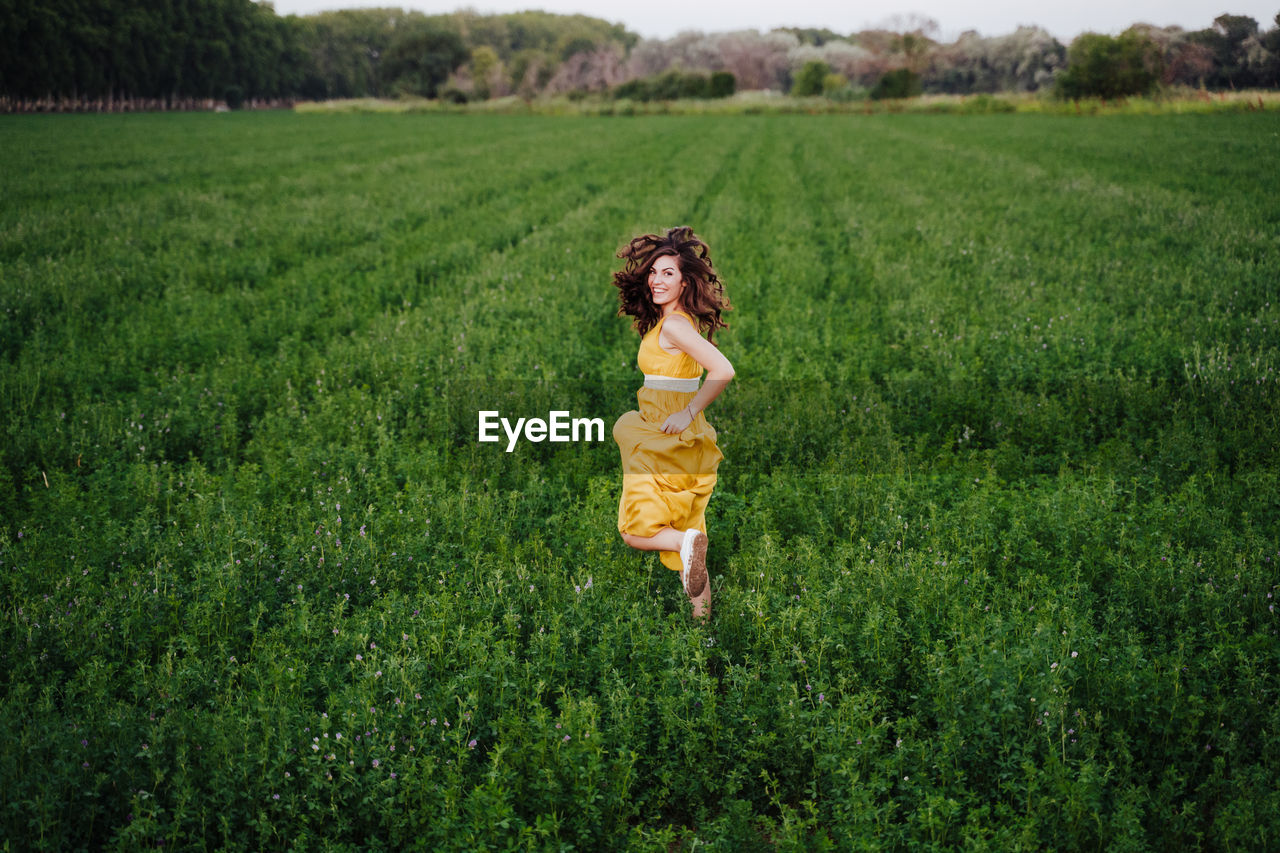 Rear view of woman running amidst plants