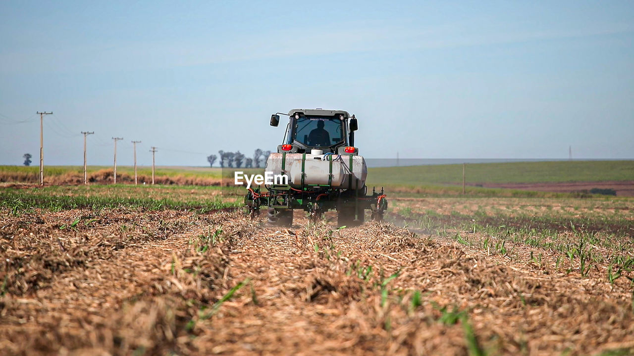 VIEW OF TRACTOR ON FIELD AGAINST SKY