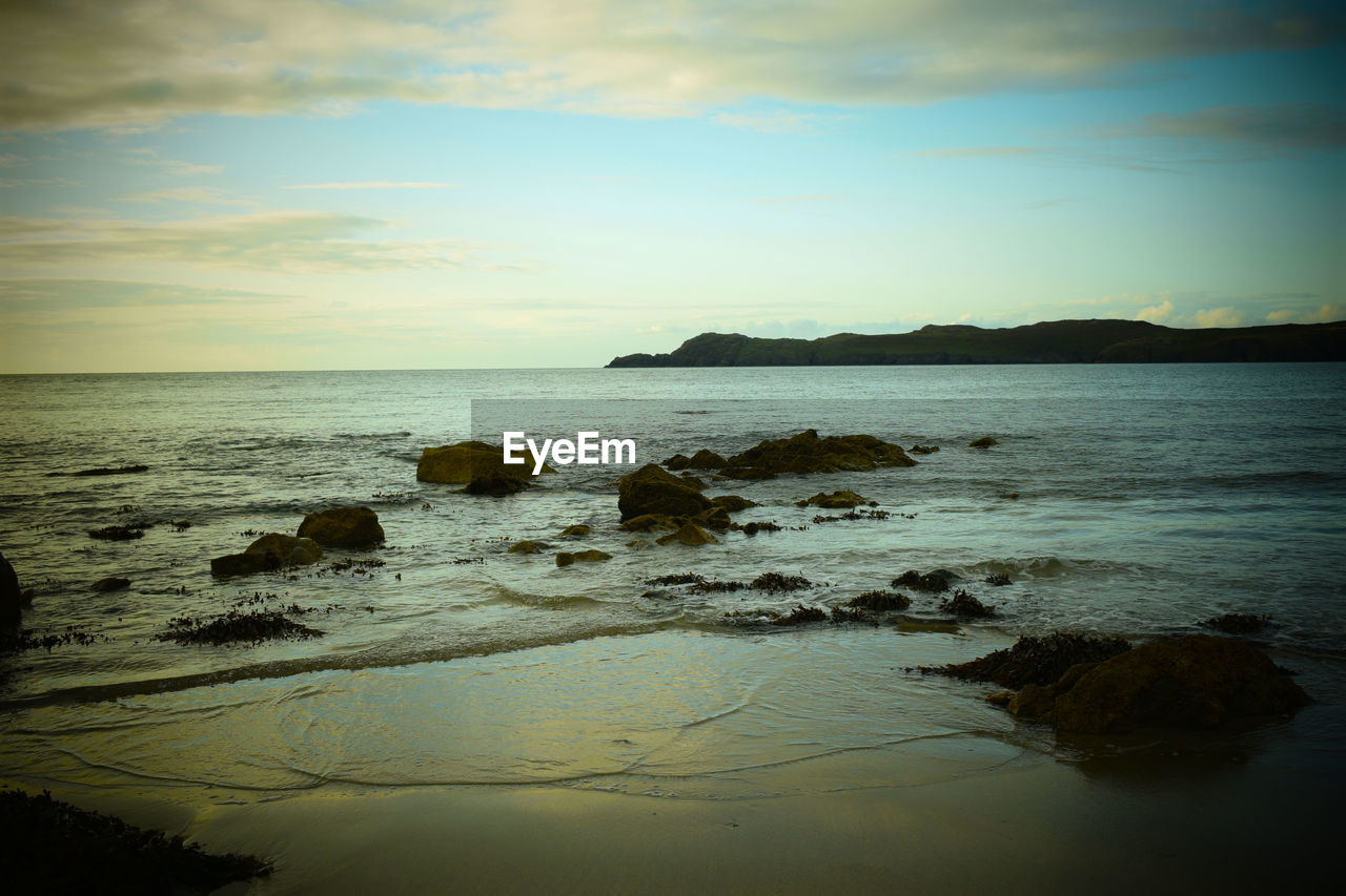 SCENIC VIEW OF BEACH AT SUNSET