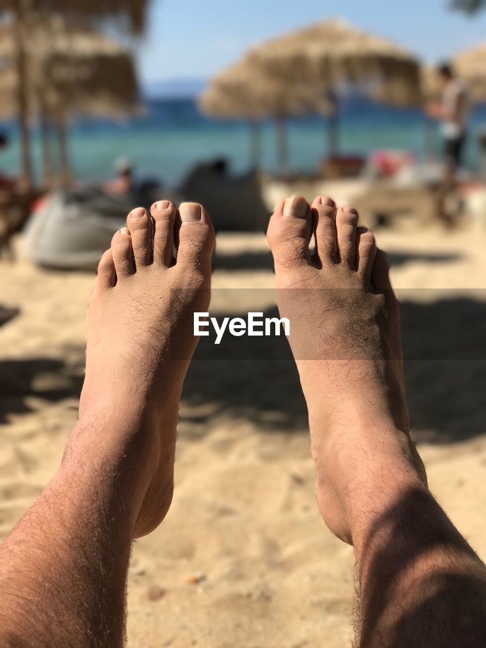 LOW SECTION OF PEOPLE RELAXING ON BEACH