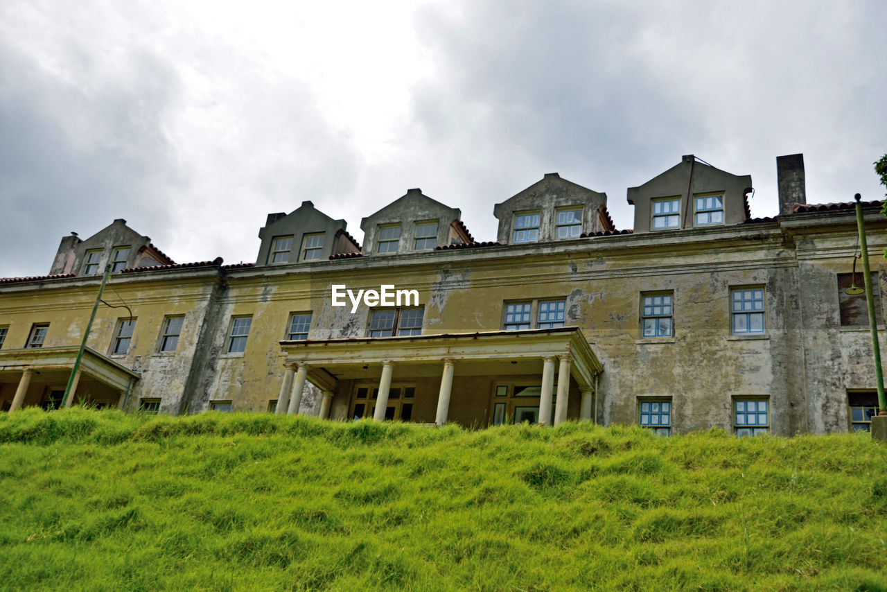 EXTERIOR OF HOUSE AGAINST CLOUDY SKY