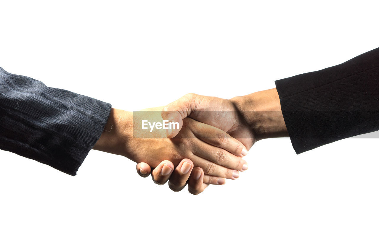 Cropped image of business people shaking hands against white background