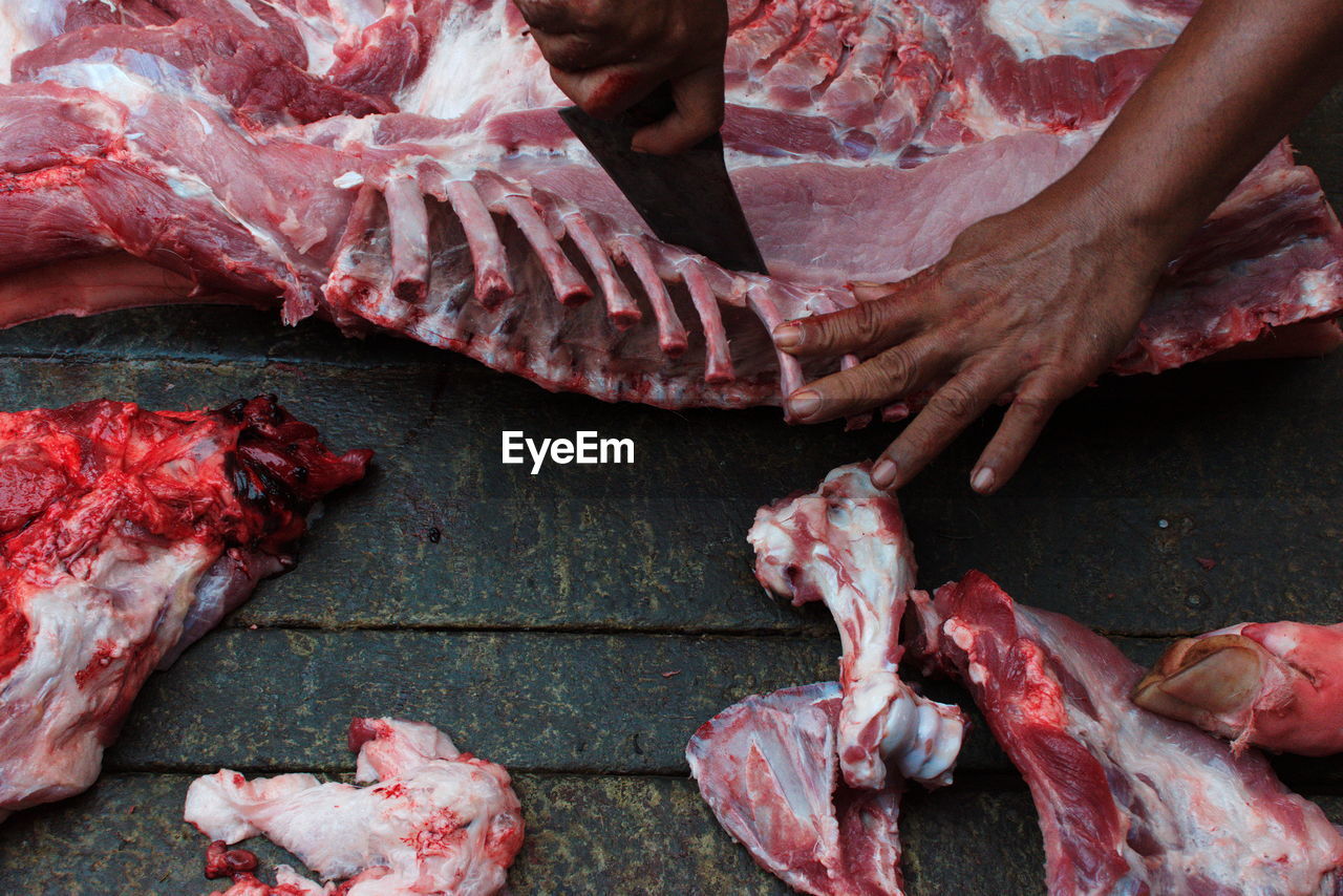 Close-up of human hand cutting meat