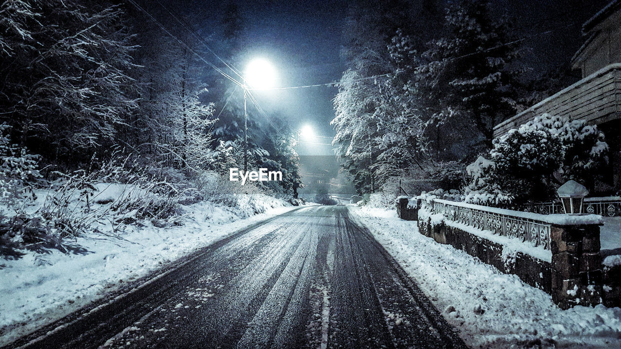 VIEW OF ILLUMINATED ROAD AT NIGHT