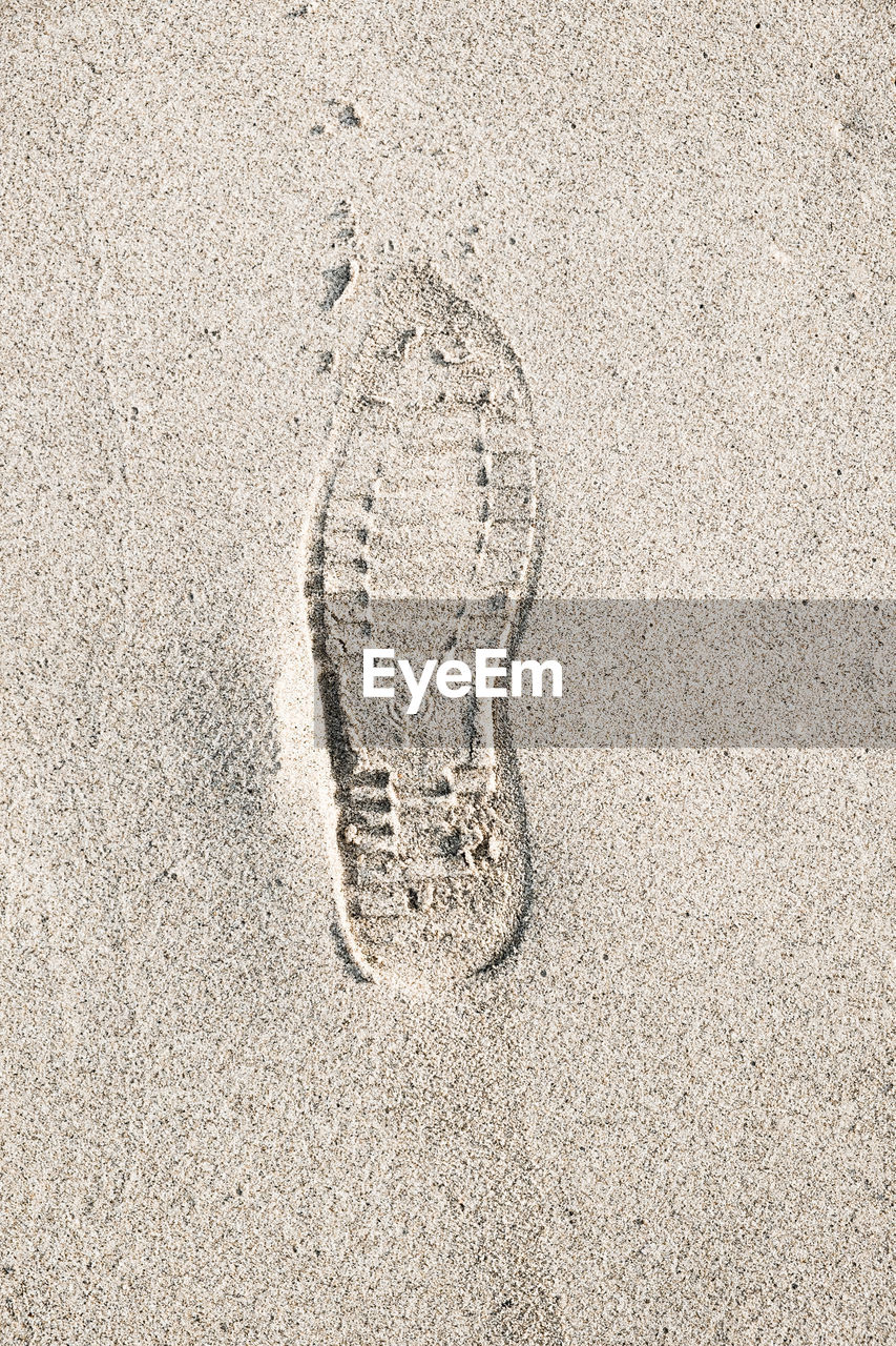 HIGH ANGLE VIEW OF FOOTPRINTS ON BEACH