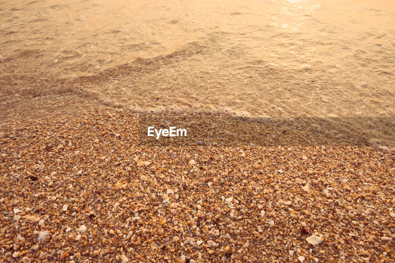 HIGH ANGLE VIEW OF PEBBLES ON BEACH