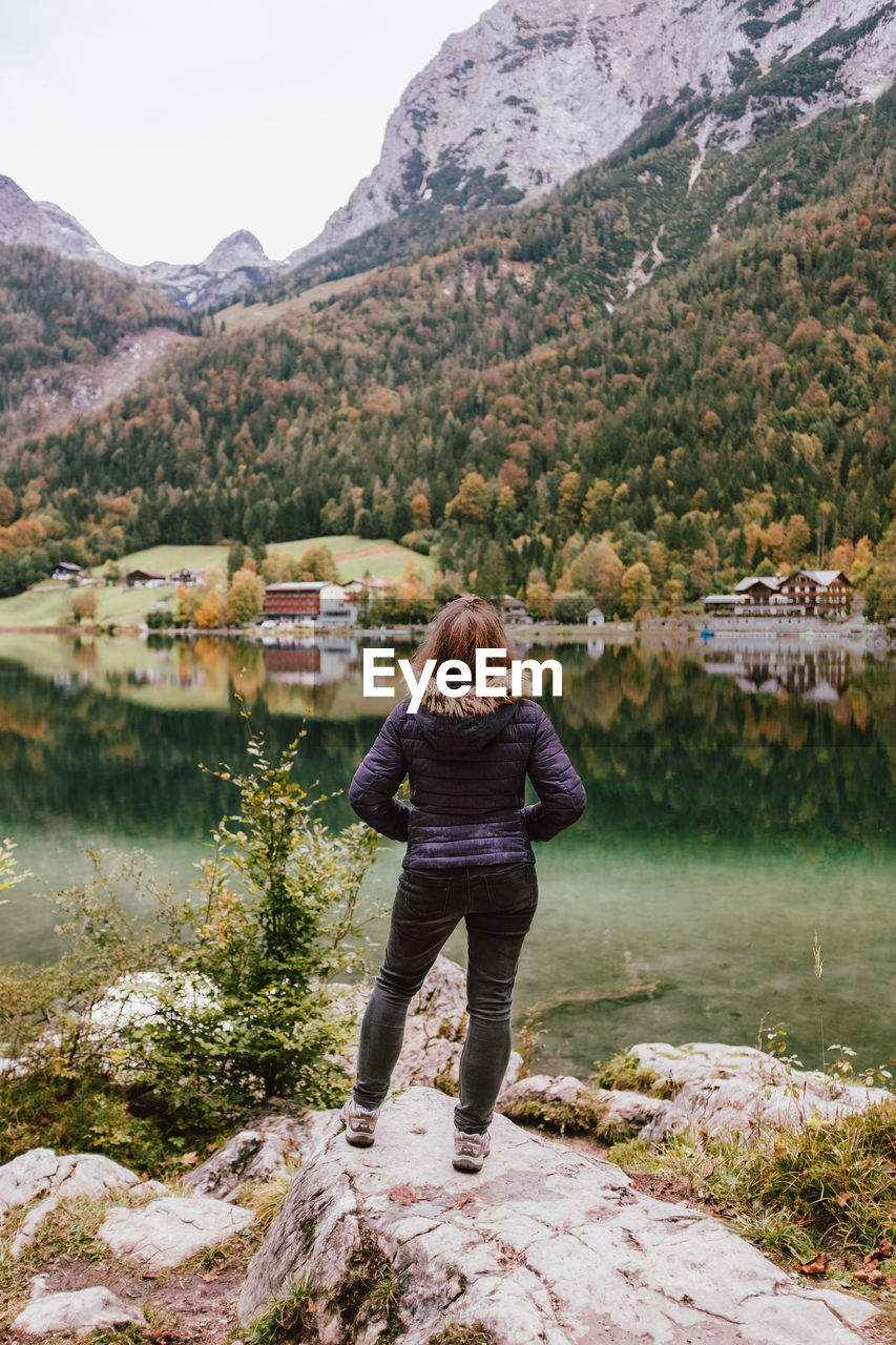 FULL LENGTH REAR VIEW OF WOMAN STANDING ON MOUNTAIN