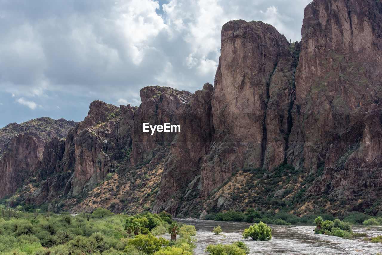 Rock formations by mountain against sky