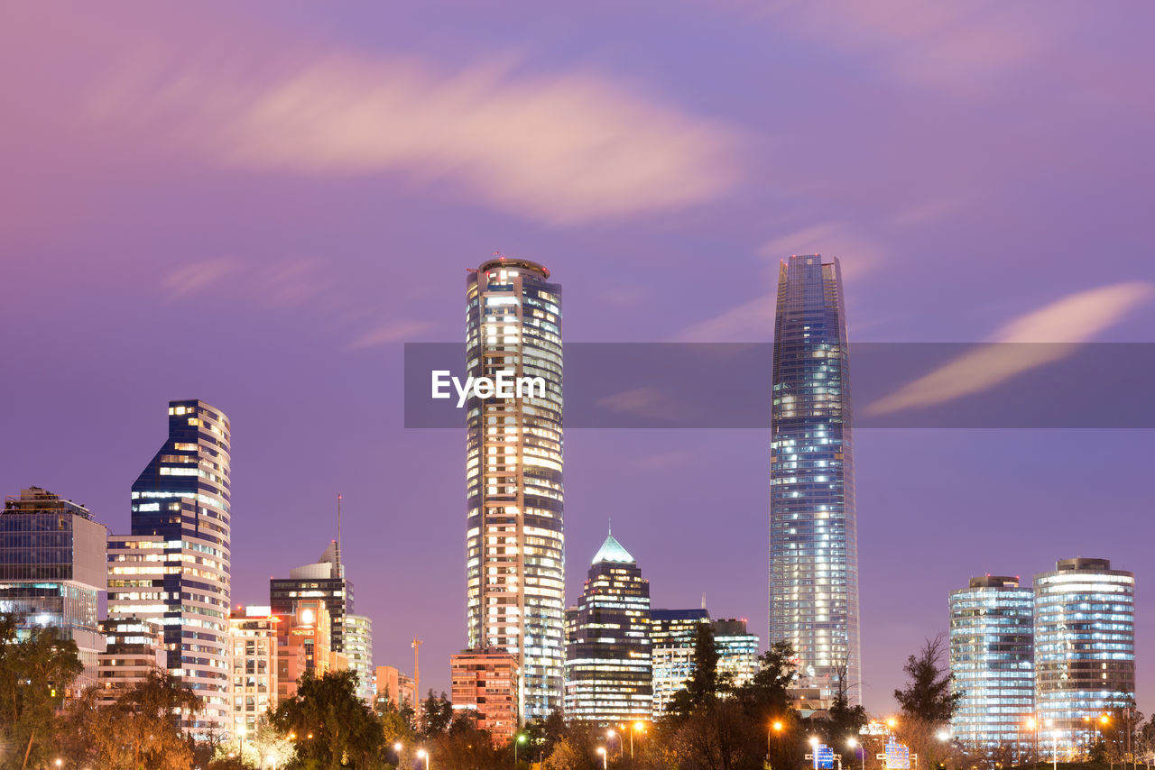 LOW ANGLE VIEW OF ILLUMINATED BUILDINGS AGAINST SKY AT CITY