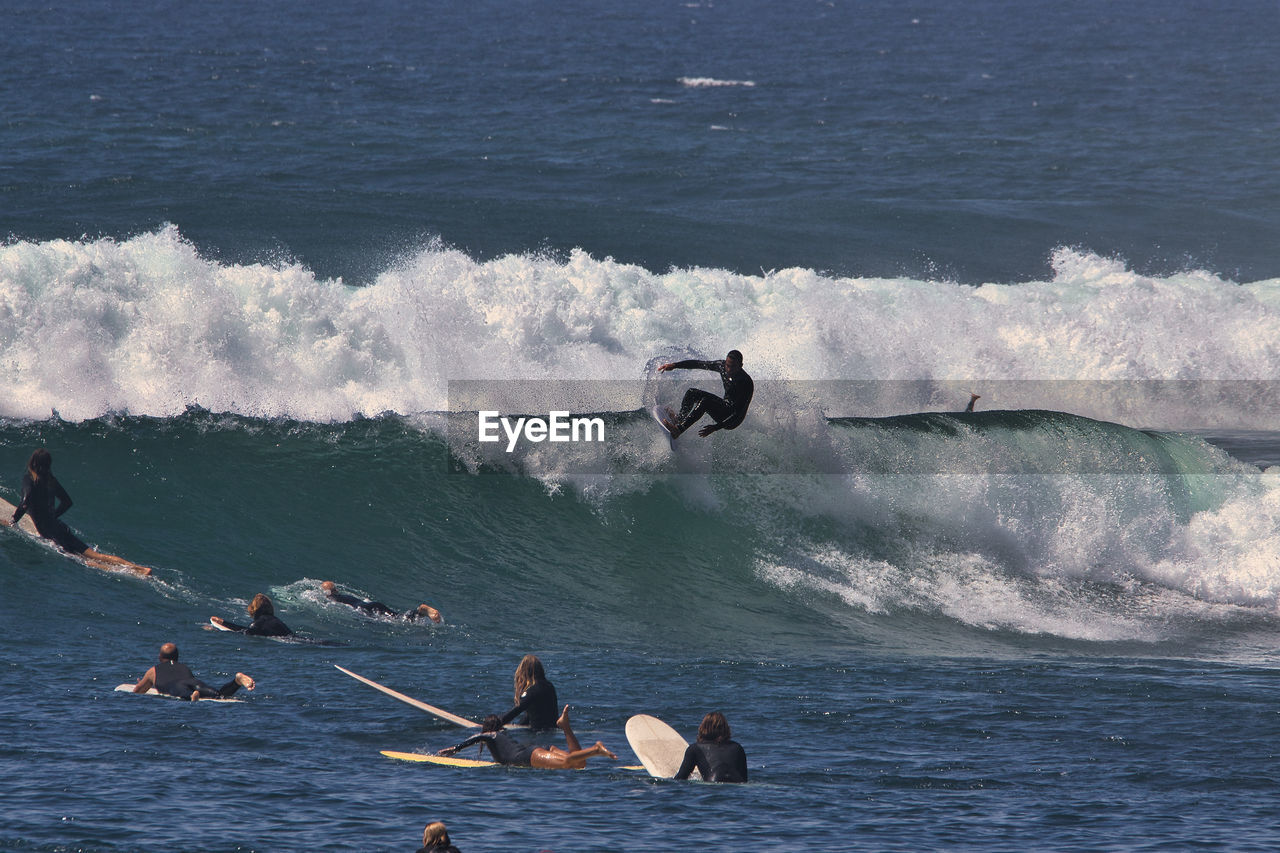 PEOPLE SURFING IN SEA