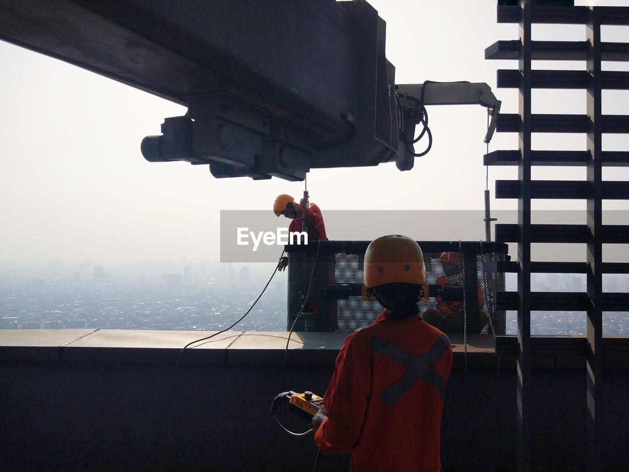 Rear view of man working on highrise building