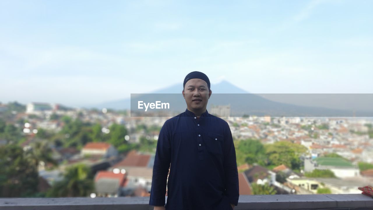 Portrait of a young man standing against the sky