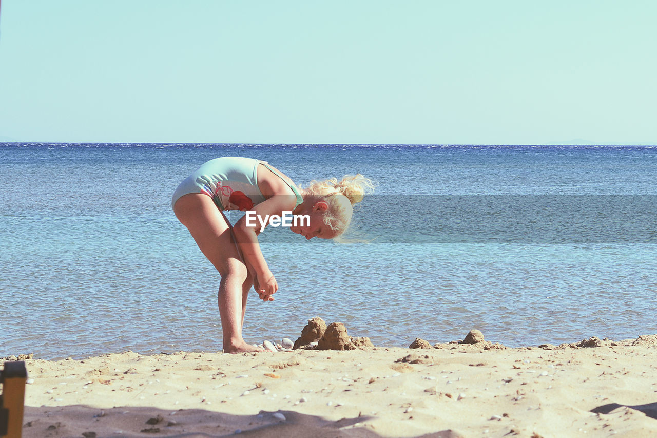 Girl on beach against sky